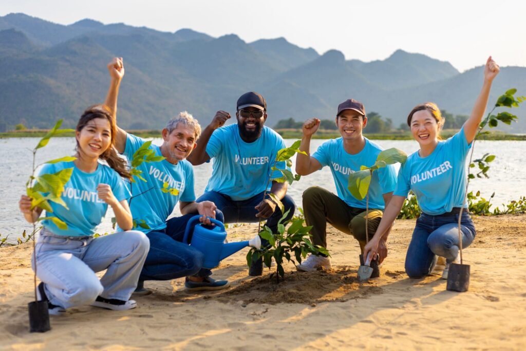 group-of-volunteers-planting-small-trees-by-the-beach-scaled